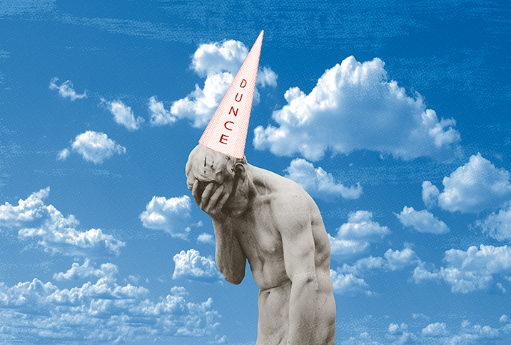 stone statue covers its face and wears a cone shaped dunce hat with a blue cloud background 