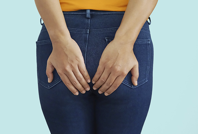 hands cover person's buttocks region in skinny jeans