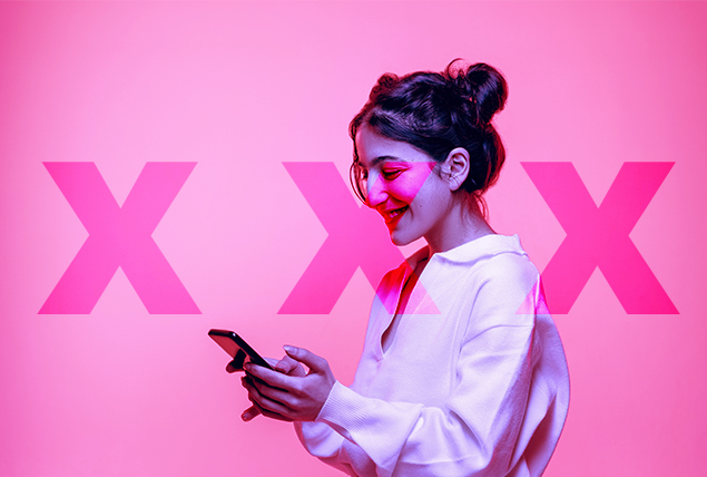woman smiles looking down at phone on pink background with three Xs