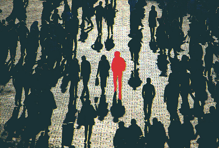 A red figure is in the center of a dark crowd walking on the road.