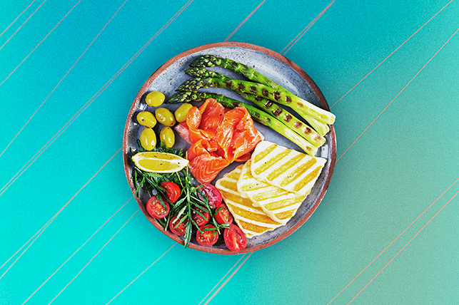 An arial view shows a plate of Mediterranean food sitting on a blue background.