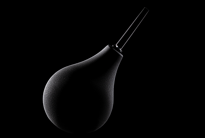 a black douche bulb on black background in shadows