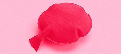 A red whoopee cushion on a pink background.