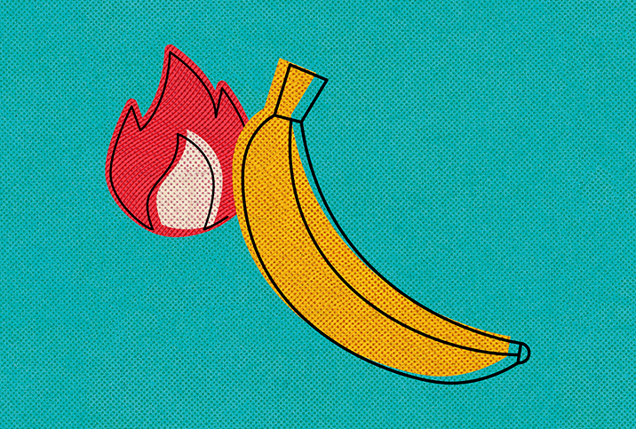 A flame burns towards the tip of a banana.