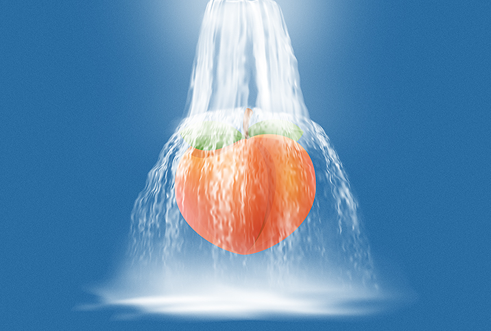 orange peach being showered in white liquid on blue background