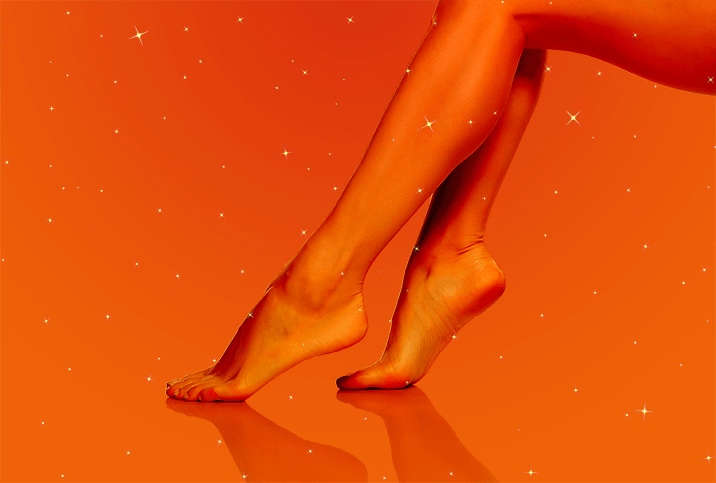 woman's feet pointed with warm orange tint and sparkles 