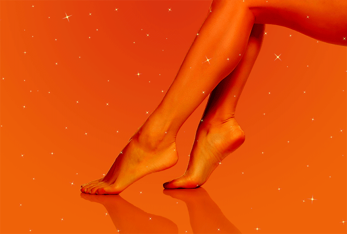 woman's feet pointed with warm orange tint and sparkles