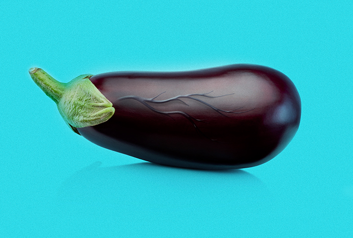 An eggplant with raised veins on a blue background