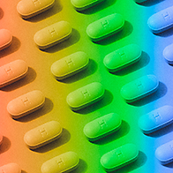 Pills are arranged in a pattern with a rainbow-colored overlay.