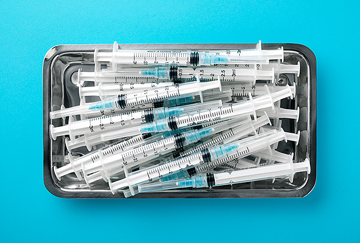 A tray of needles sits against a blue surface.