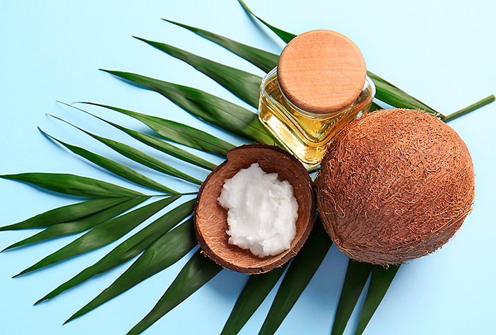 Coconut oil for private parts next to a coconut on a leaf.