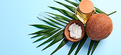 Coconut oil for private parts next to a coconut on a leaf.