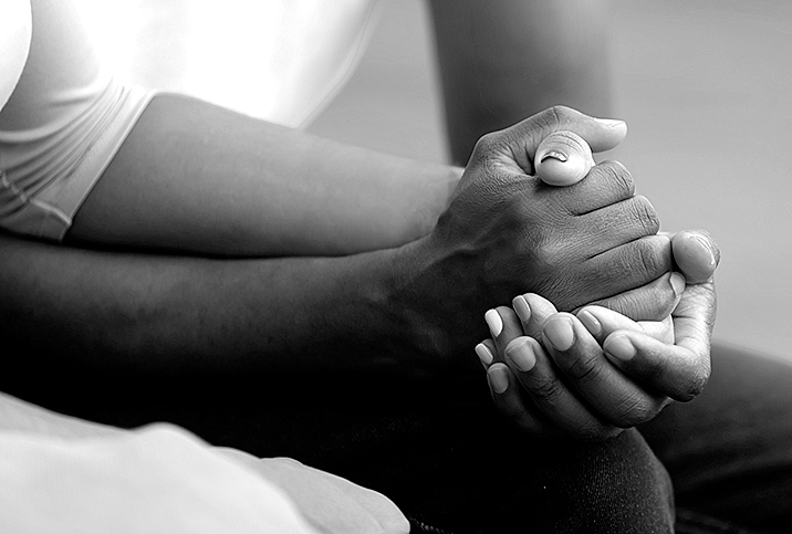 A couple hold hands while they attend sex therapy.