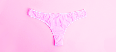 Pink panties on a pink background with red droplets.