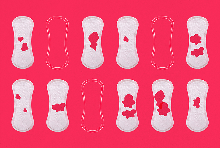 Twelve-menstrual-pads-in-two-horizontal-rows-some-with-red-blood-spots