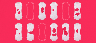 Twelve-menstrual-pads-in-two-horizontal-rows-some-with-red-blood-spots