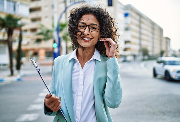 A-smiling-woman-in-glasses-touches-her-hair