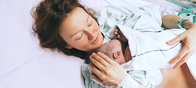 A mother holds her newborn baby after childbirth.