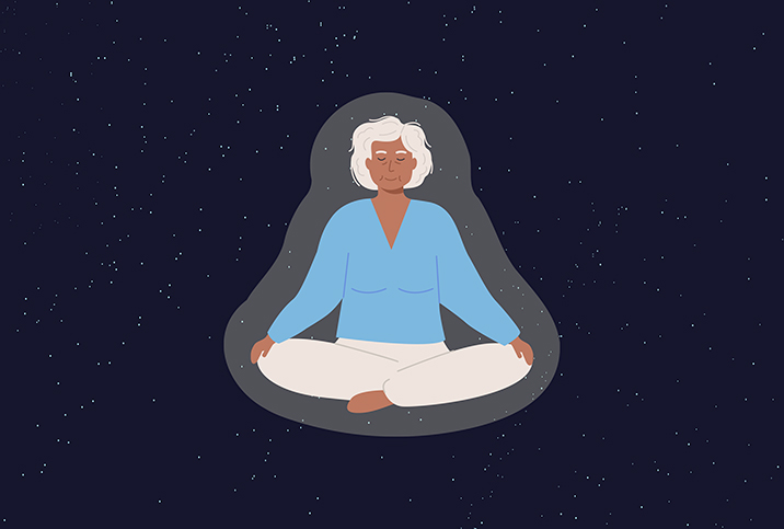 An elder woman sits cross-legged with her eyes closed against a starry background.