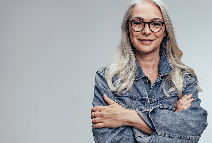 Grey-haired-woman-in-glasses-crosses-her-arms