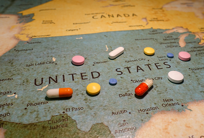 Pills are scattered over a map of the US.