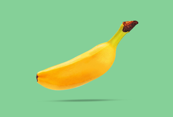A shrunken, floating banana casts a small shadow on its green background.
