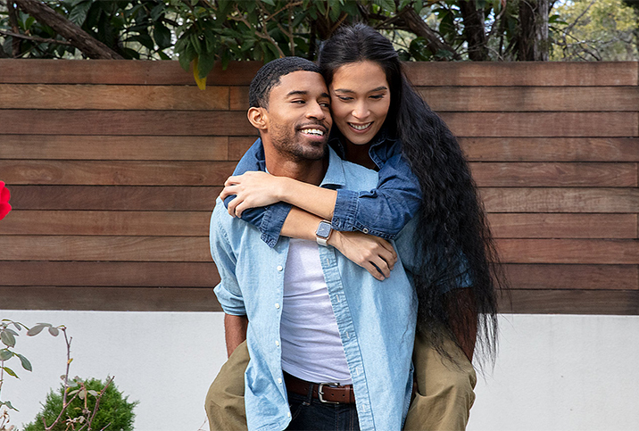 A man gives a piggyback ride to a woman.