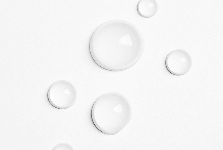 Water drops are bubbled against a white surface.