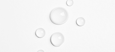Water drops are bubbled against a white surface.