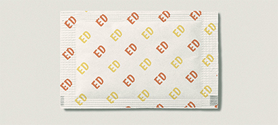 A sugar packet has ED written in yellow and orange repeatedly in a pattern.