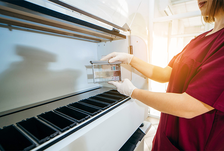 A technician pulls out slides of breast biopsies to determine if they are cancerous.