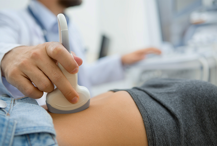 A woman is getting an ultrasound done on her pelvic region.