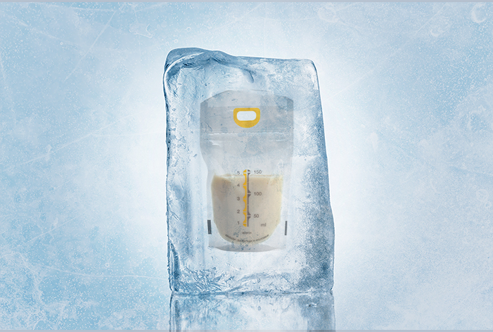 A bag of breast milk sits is frozen inside of an large block of ice.