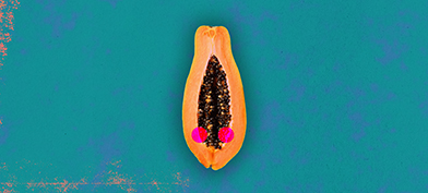 Half of a papaya is against a teal background with two red dots along either side of the open center.