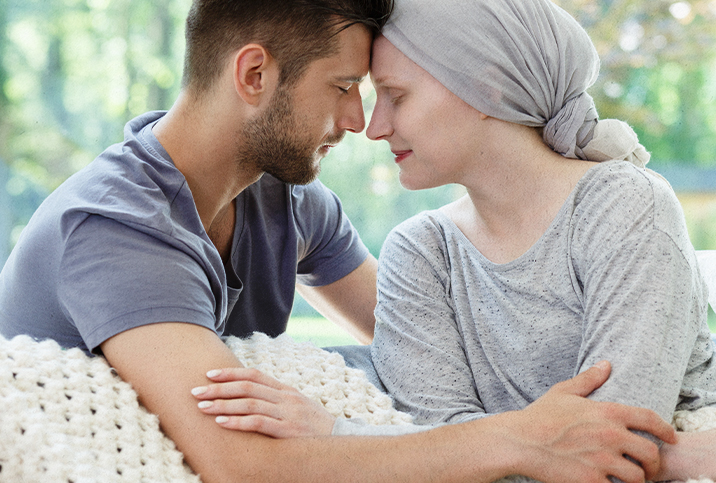 A woman touches foreheads with a man after undergoing chemotherapy for pancreatic cancer.