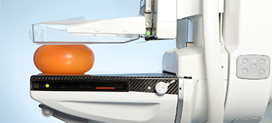 A orange, plastic ball gets compressed in a mammogram machine. 