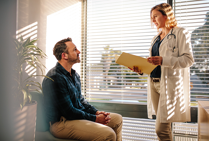 A man with testicular cancer and depression listens to his doctor speaking.