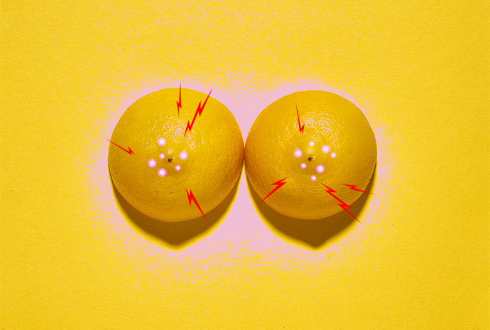 Two lemons, with their pointed sides up, have pink dots and red lightning around the centers. 