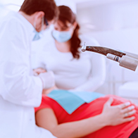A pregnant woman is having her teeth examined at the dentist.
