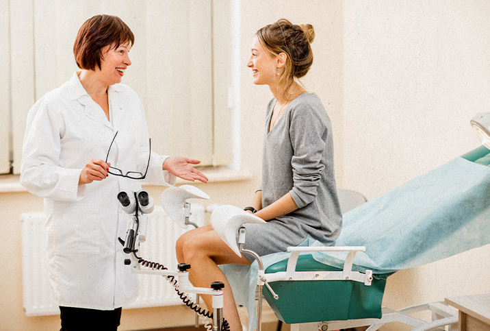 A woman sits talking to her gynecologist during her first visit alone.