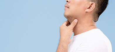 A man holds his hand along his throat to check his glands.