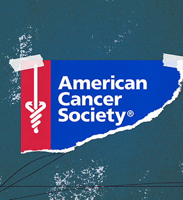 A torn page with the American Cancer Society logo is taped to a blueish grey background.