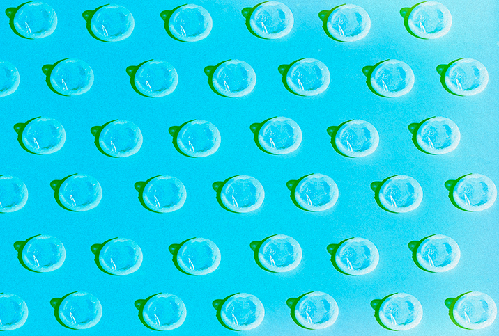 A pattern of white condoms repeat against a blue background.