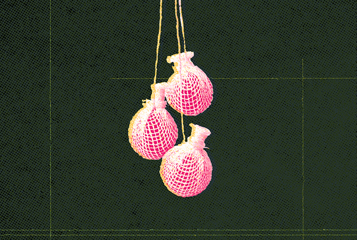Three pink yoni pearls dangle together against a textured dark green background.