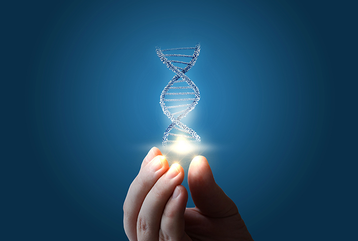 A DNA strand is lit up and held by a hand at the fingertips against a blue background.