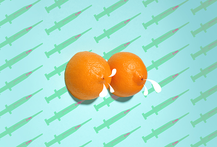 Two halfs of an orange sit side-by-side with milk coming from the ends against a background of botox needles.