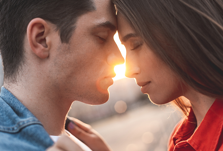 A man and woman press their foreheads against each other with their eyes closed.