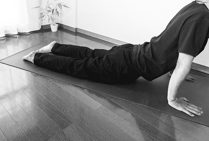 A man stretches his pelvic floor during an exercise on a yoga mat.