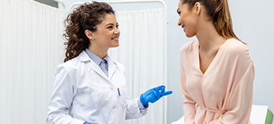 A college student talks to her OB-GYN during a routine visit.
