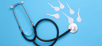 A stethoscope lays against a blue surface with white sperm swimming towards the chest piece.